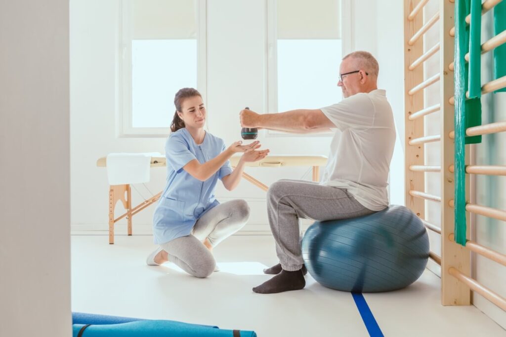 Osoba starsza uczestniczy w treningu rehabilitacyjnym z fizjoterapeutką w Białymstoku.