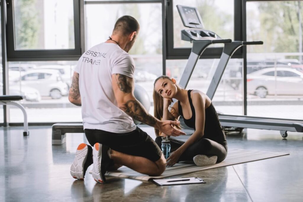 Trening personalny w Białymstoku, gdzie trener omawia ćwiczenia z klientką na siłowni.