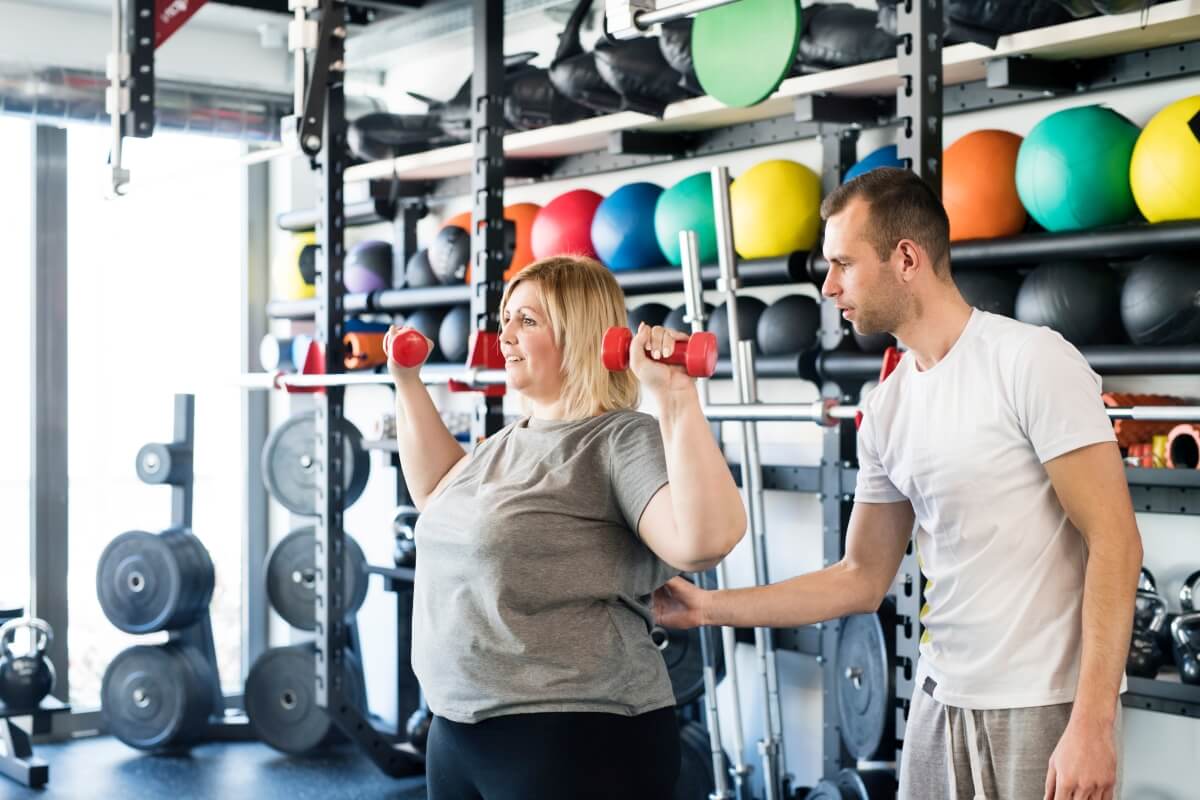 Osoba ćwiczy z trenerem w Białymstoku, gdzie trening i dieta na odchudzanie są popularne.